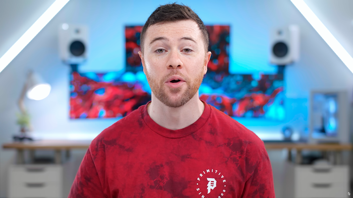 Lo YouTuber randomfrankp usa varie sorgenti luminose nel suo sfondo, dalla lampada da scrivania, alle strisce luminose, ai monitor del computer e persino il suo computer.