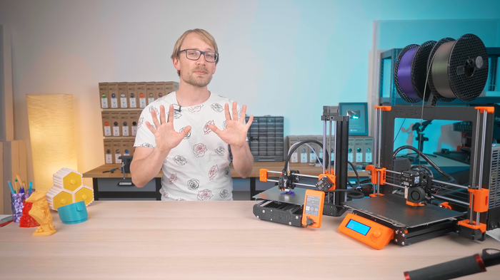 La scena di Thomas Sanladerer mostra gli strumenti che usa per la stampa 3D e alcune stampe completate.
